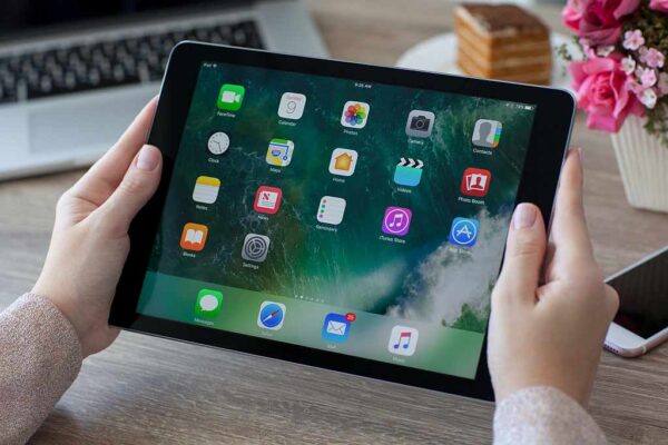 Foto eines von einer Frau gehaltenen iPads mit zahlreichen APPs