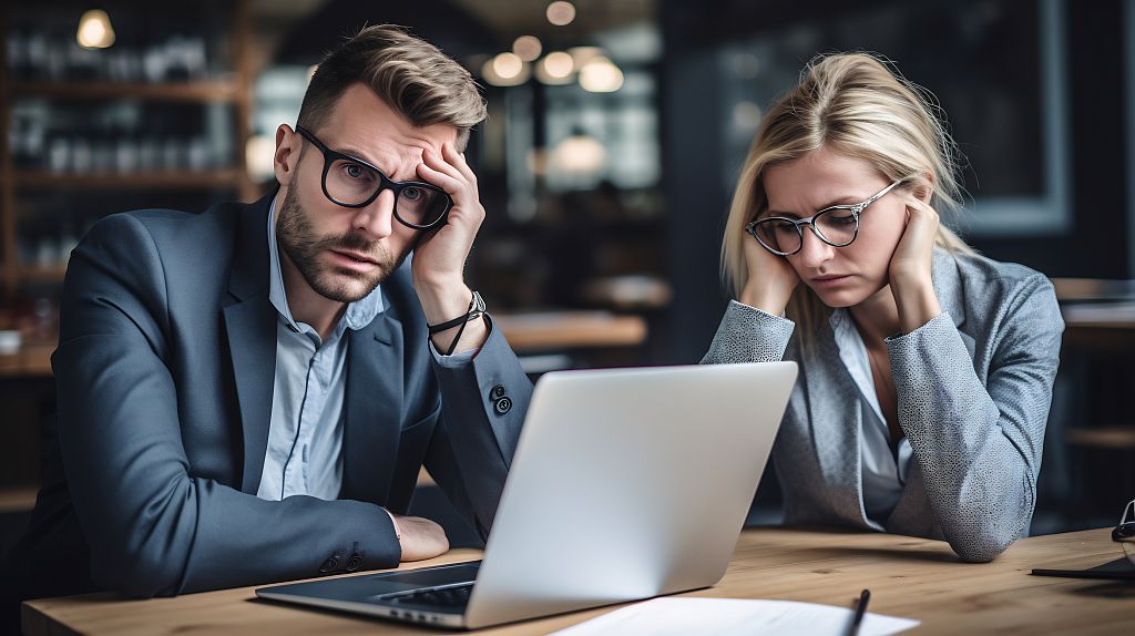 Zwei durch die Arbeit erschöpfte Personen, Foto: Adobe Stock