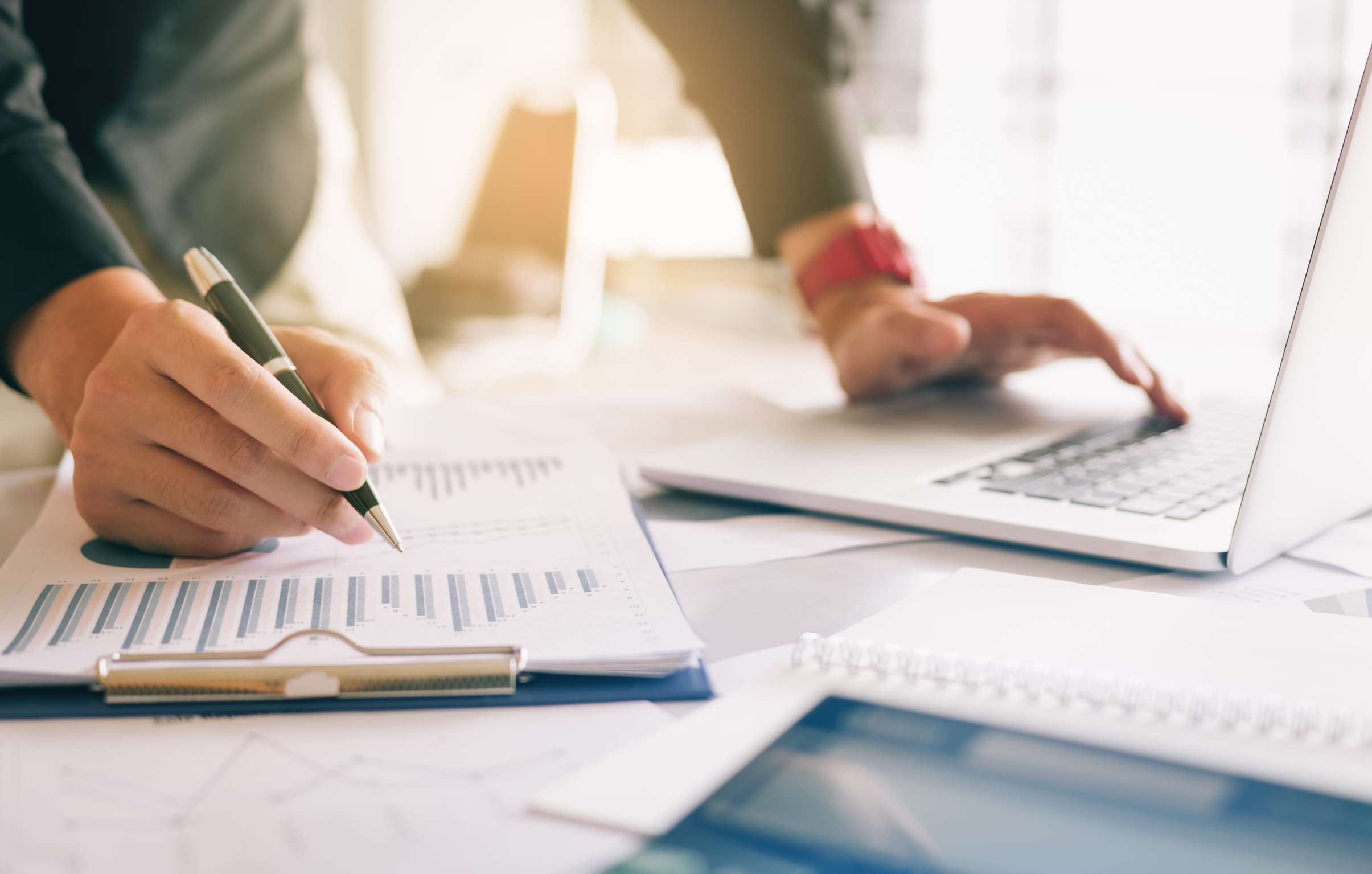 Businessman holding pen and pointing paper chart summary analyzi