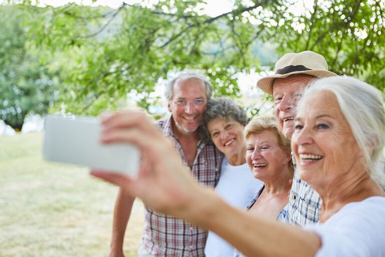 Senior Frau mit Smartphone macht ein Selfie, Foto: Adobe Stock
