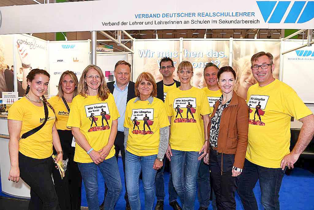 Ein starkes Team: Die lehrer nrw Standbesetzung mit dem Landesvorsitzenden Sven Christoffer (rechts) und dem VDR-Bundesvorsitzenden Jürgen Böhm (4.v.l.). Foto: Friedhelm Windmueller Ein starkes Team: Die lehrer nrw Standbesetzung mit dem Landesvorsitzenden Sven Christoffer (rechts) und dem VDR-Bundesvorsitzenden Jürgen Böhm (4.v.l.). Foto: Friedhelm Windmueller