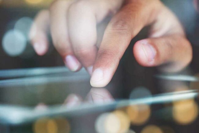 Foto mit einem iPad, das durch Berührung mit dem Finger bedient wird