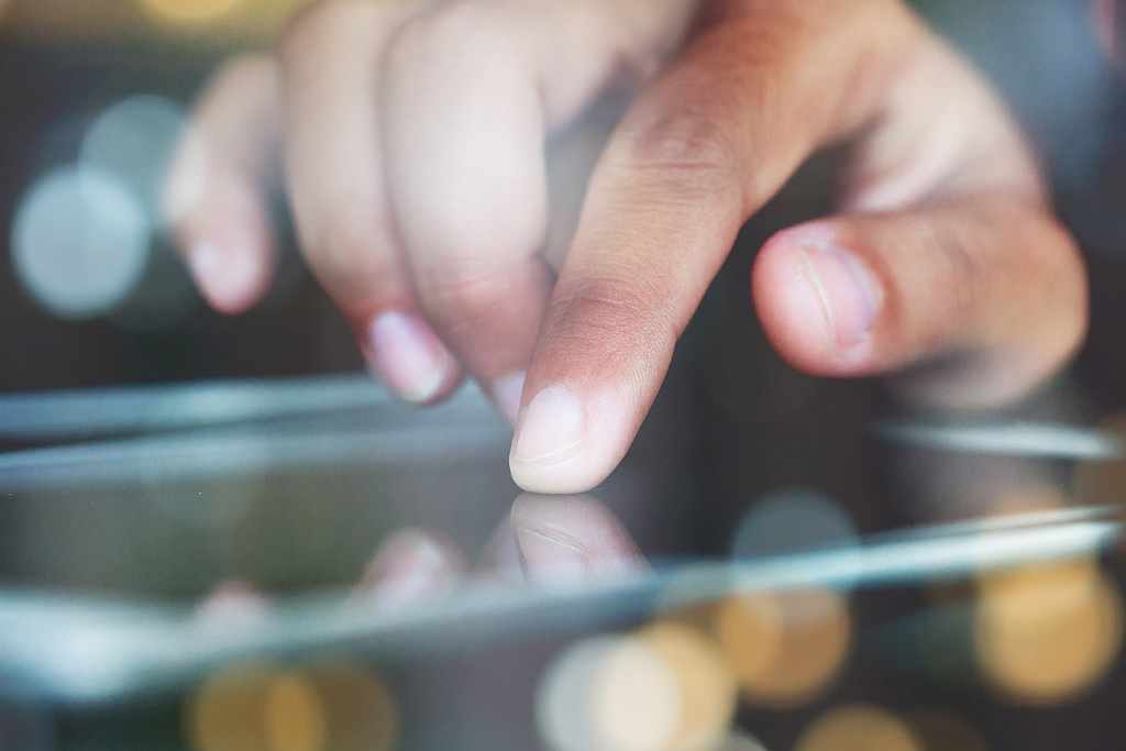 iPad Bedienung, Foto: Adobe Stock Foto mit einem iPad, das durch Berührung mit dem Finger bedient wird